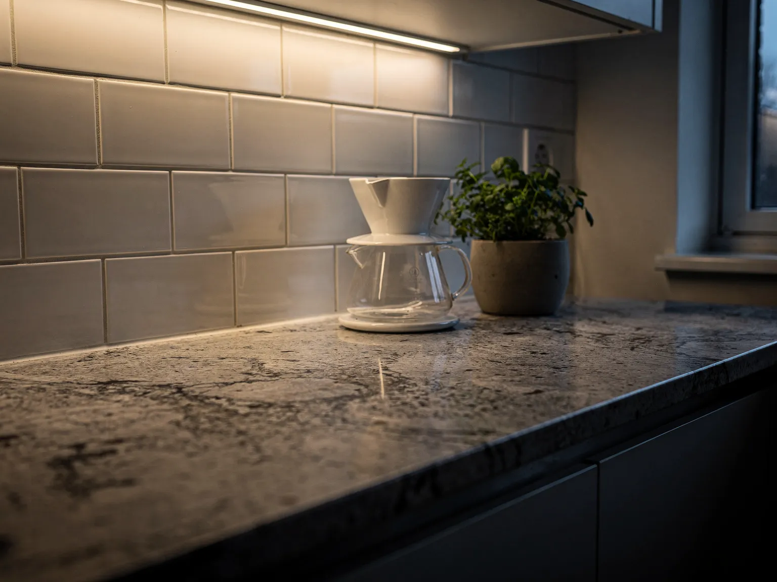 Under-cabinet lighting on granite countertop with coffee maker
